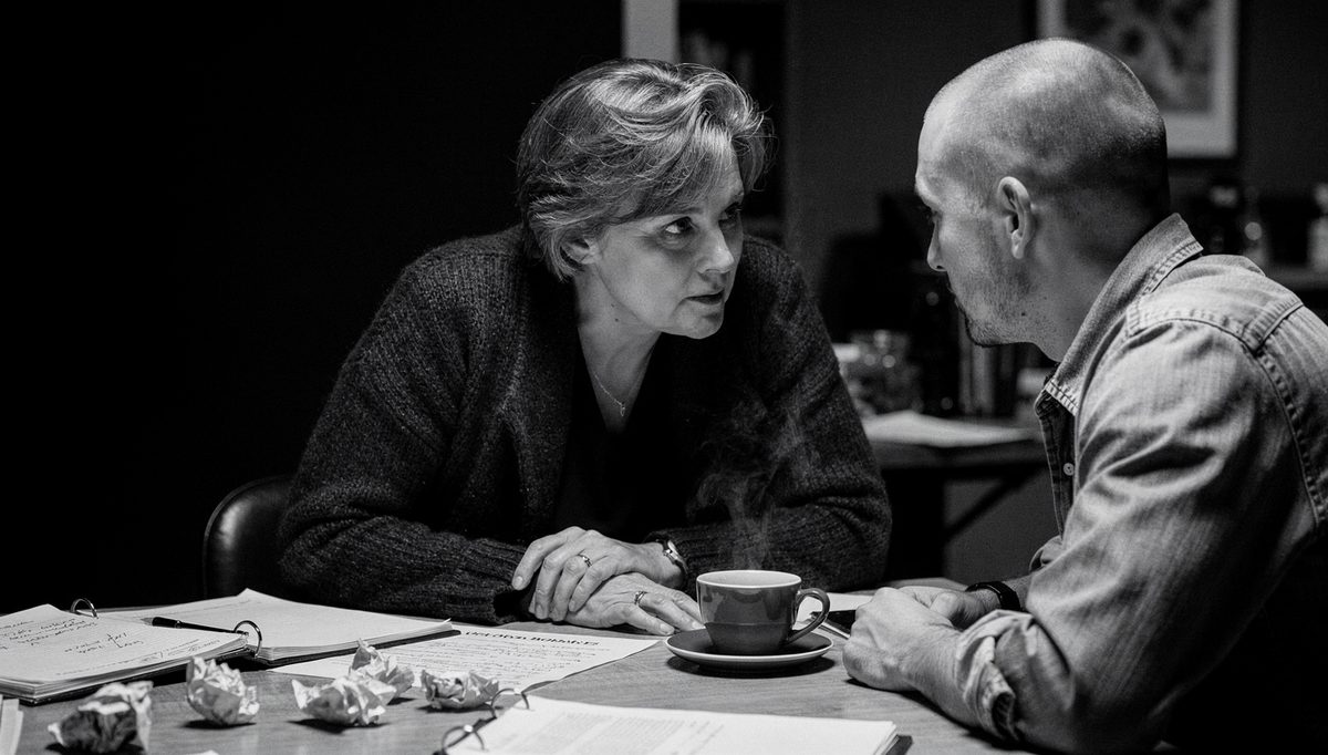 Two colleagues reviewing give feedback debrief notes at table