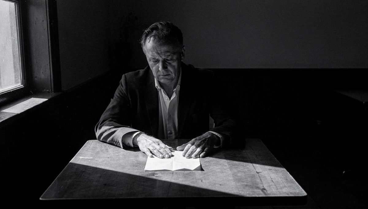 Man alone at table confronting emotional blind spots in silence