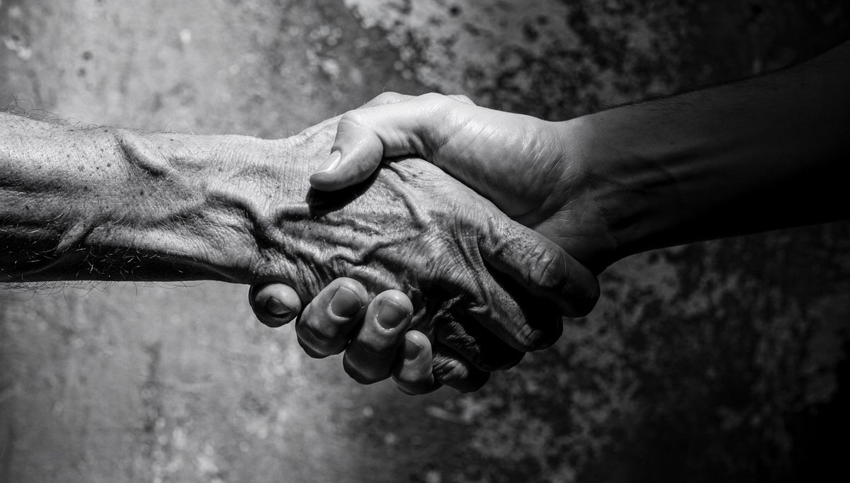 Two hands in a firm handshake, illustrating haptics in communication